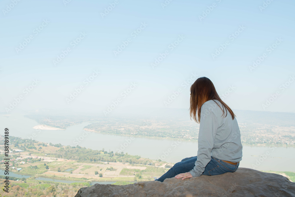 Young woman happy and relaxing in mountains with sunlight