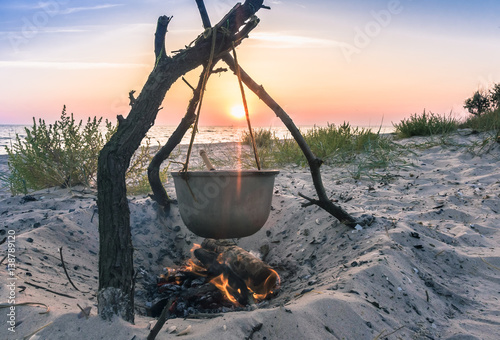 Photo of cauldron with food on seaside
