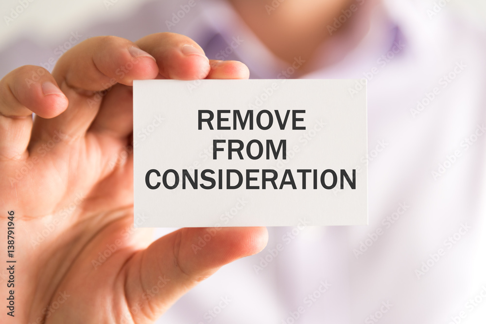 Businessman holding a card with REMOVE FROM CONSIDERATION message Businessman holding a card with REMOVE FROM CONSIDERATION message