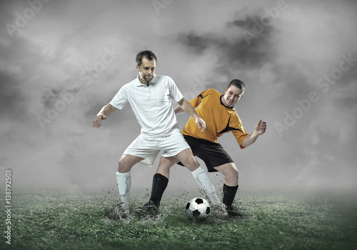 Football player with ball in action under sky with clouds © Andrii IURLOV