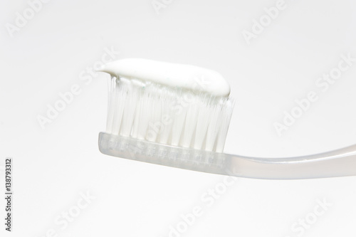 Toothpaste on the toothbrush in a light tone.