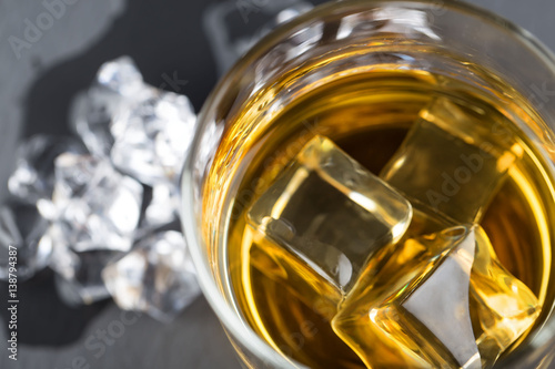 A fragment of round glass of whiskey with ice