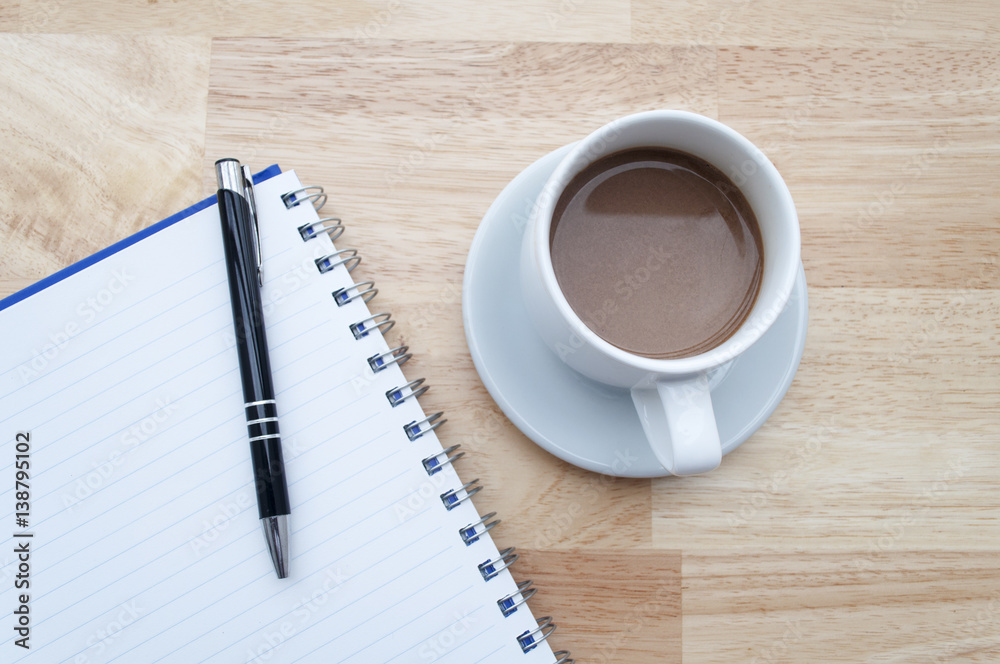 coffee with notebook on wooden table, view from above coffee with notebook on wooden table, view from above