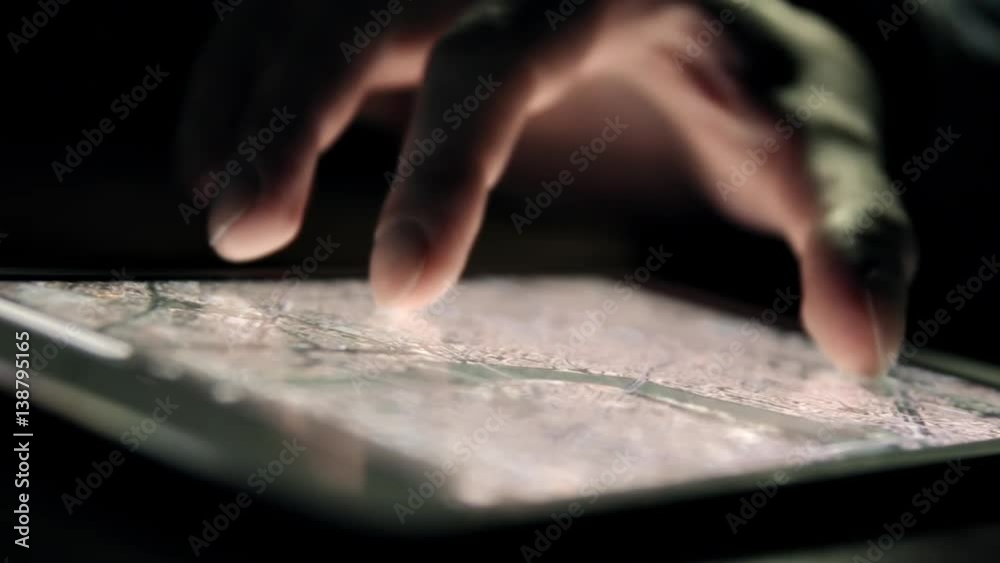 Browsing city map on tablet PC in the dark. Man's hand and screen close-up. Browsing city map on tablet PC in the dark. Man's hand and screen close-up.