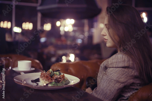 portrait of a pensive girl in a restaurant at the table