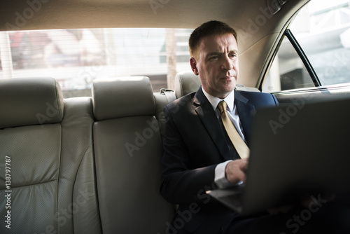 Businessman Using Laptop Car Inside © Rawpixel.com