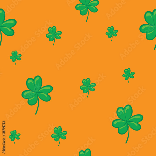 Vector seamless floral pattern with decorative green leaves of clover on an orange background. Wallpaper, textile, tissue, background. Vector illustration.
