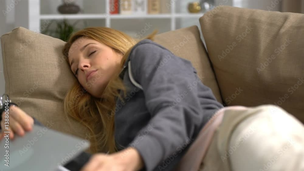 young woman sleeping with laptop on the sofa at home and drops the laptop. young woman sleeping with laptop on the sofa at home and drops the laptop.