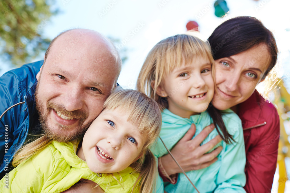 Φωτογραφία Joyful family of four posing for photography while having fun in sunny spring pa