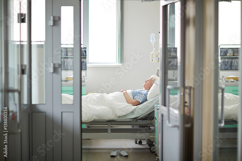 Quadro su tela Wide shot image of doors opened to sterile light hospital ward with sad lonely o