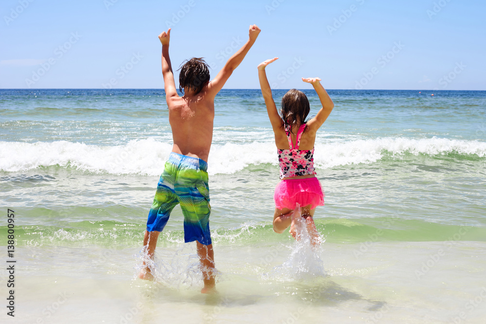 Rear view of cheerful children jumping in water Rear view of cheerful children jumping in water
