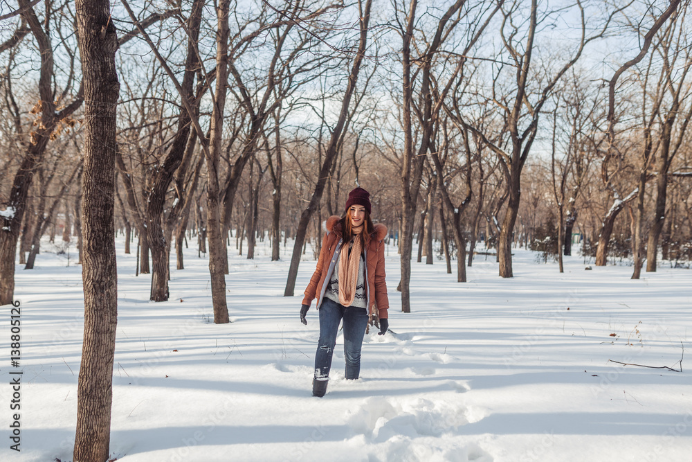 The girl walks in the snow-covered park. She as if makes the way to us through this snow layer. The girl smiles and rejoices to the events.