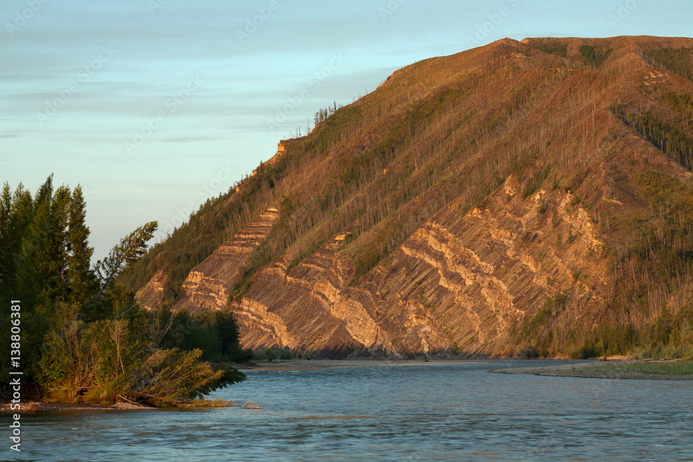 Layered rocks on the hillside above the river. The River Moma. Yakutia. Russia.