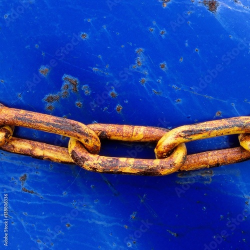 Rusty chain on blue background photo