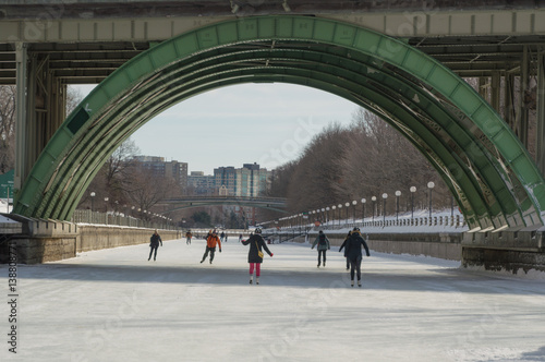 Ice skating under the bridge on the frozen Rideau Canal Ottawa Winterlude