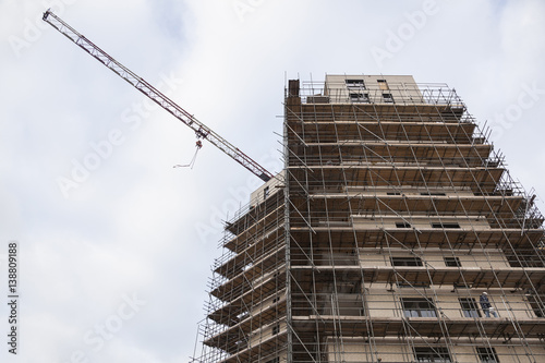 scaffolding on building site of new apartment building and crane