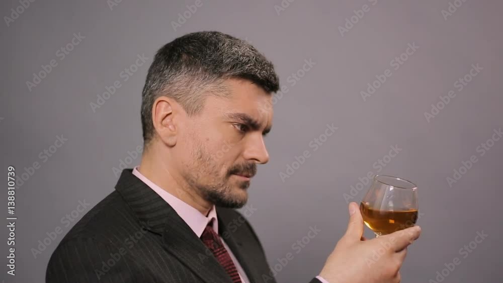 Dissatisfied connoisseur tasting cheap scotch at cafe, displeased taster Dissatisfied connoisseur tasting cheap scotch at cafe, displeased taster