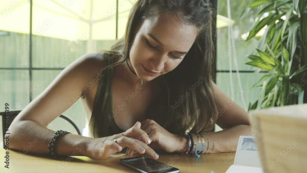 Smartphone girl using app on phone drinking coffee smiling in cafe. Beautiful young casual female professional on mobile phone. Caucasian model.