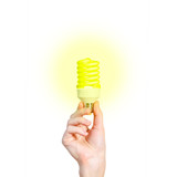 Closeup of man's hand holding energy saving lamp. Glows brightly with yellow light. Recycling, electricity, environment and ecology concept. The lamp is yellow. Isolated on white background