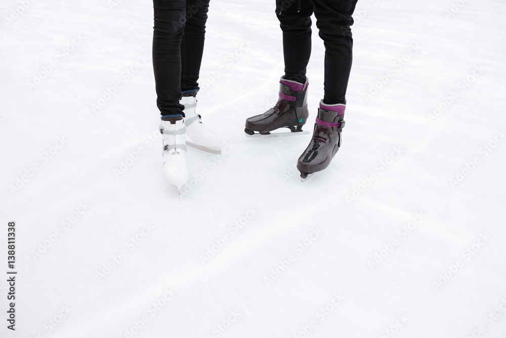 Cropped picture of young loving couple skating at ice rink Cropped picture of young loving couple skating at ice rink