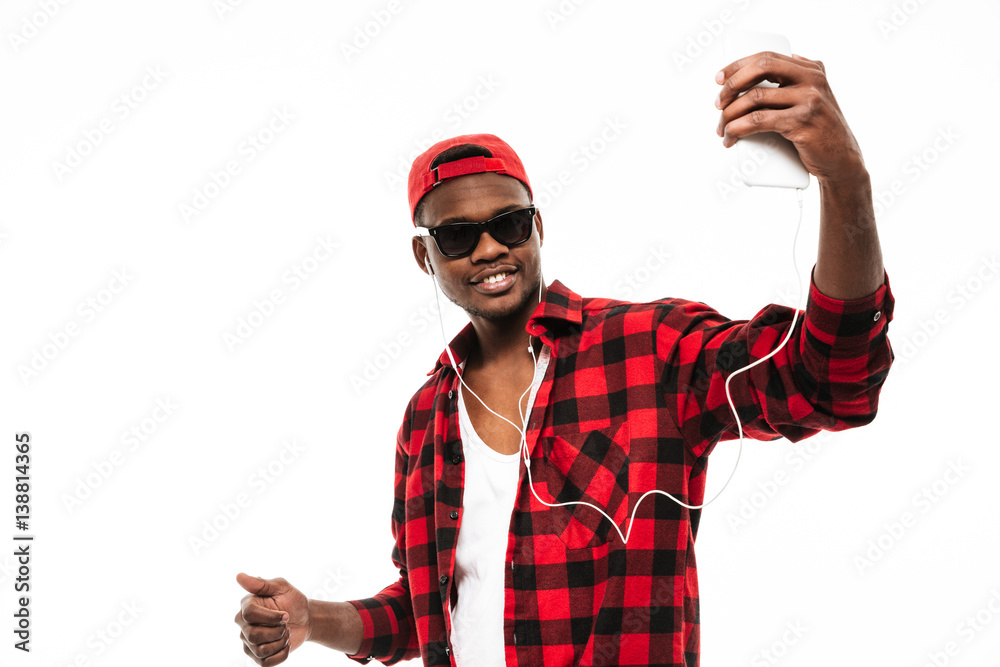 Naklejka premium Man listening to music and taking selfie with mobile phone