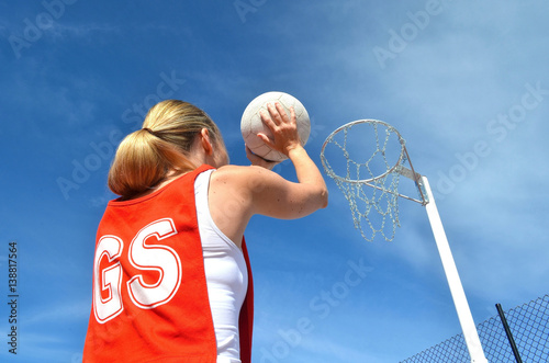 Obraz na plátně Woman shoots a netball into a netball ring