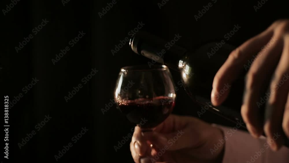 Professional winemaker pouring red wine into glass and tasting, close-up Professional winemaker pouring red wine into glass and tasting, close-up