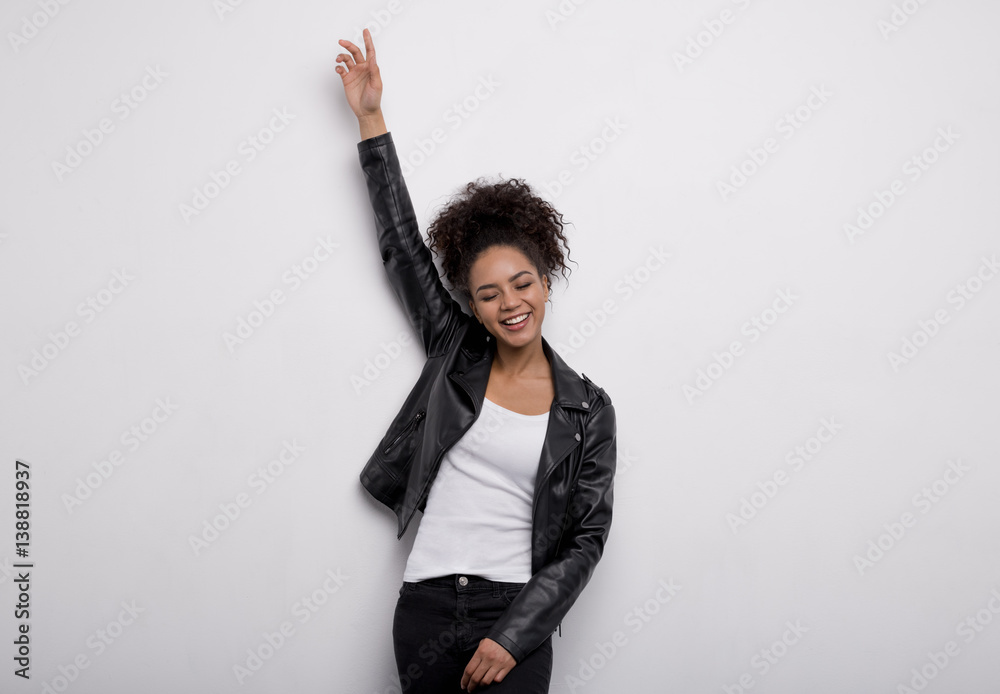 Portrait of happy young woman with raising a hand, eyes closed