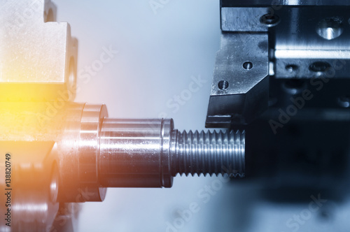 Canvas Print The CNC lath or CNC Turning machine cutting the thread with the abstract lightin