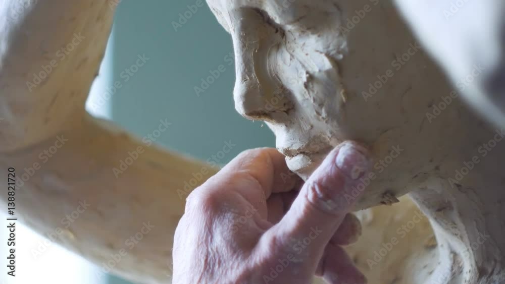 Scultor modeling woman sculpture in modeling clay