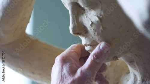 Scultor modeling woman sculpture in modeling clay