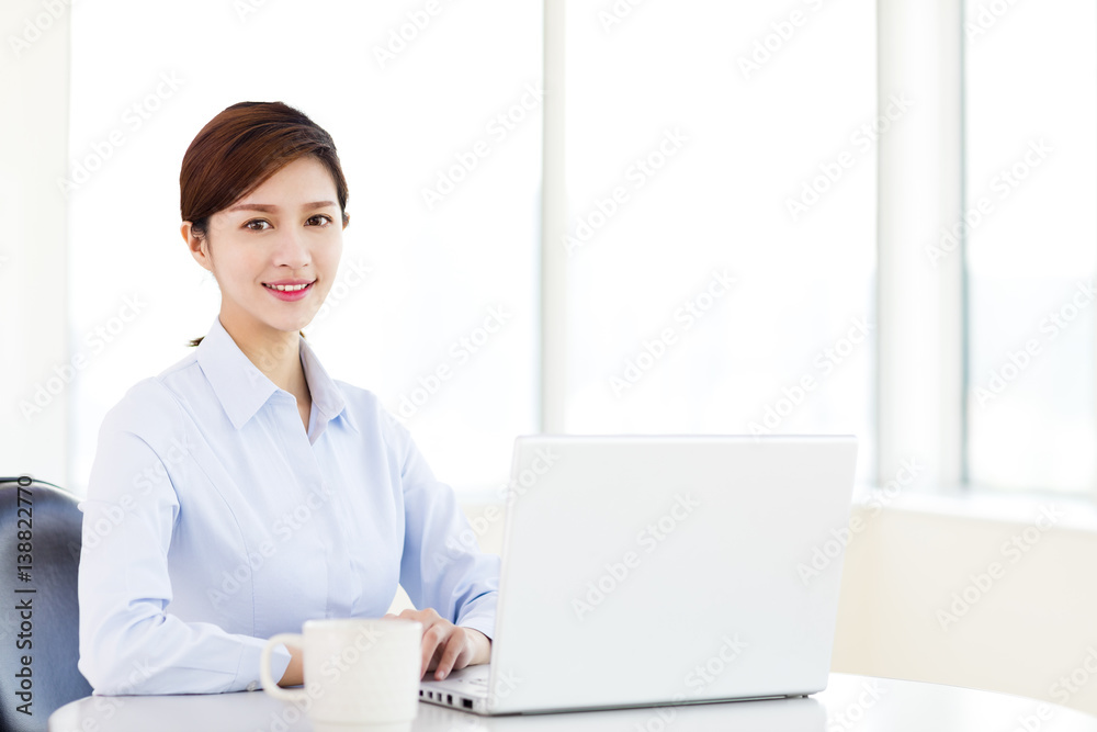 Young business woman with laptop in the office Young business woman with laptop in the office