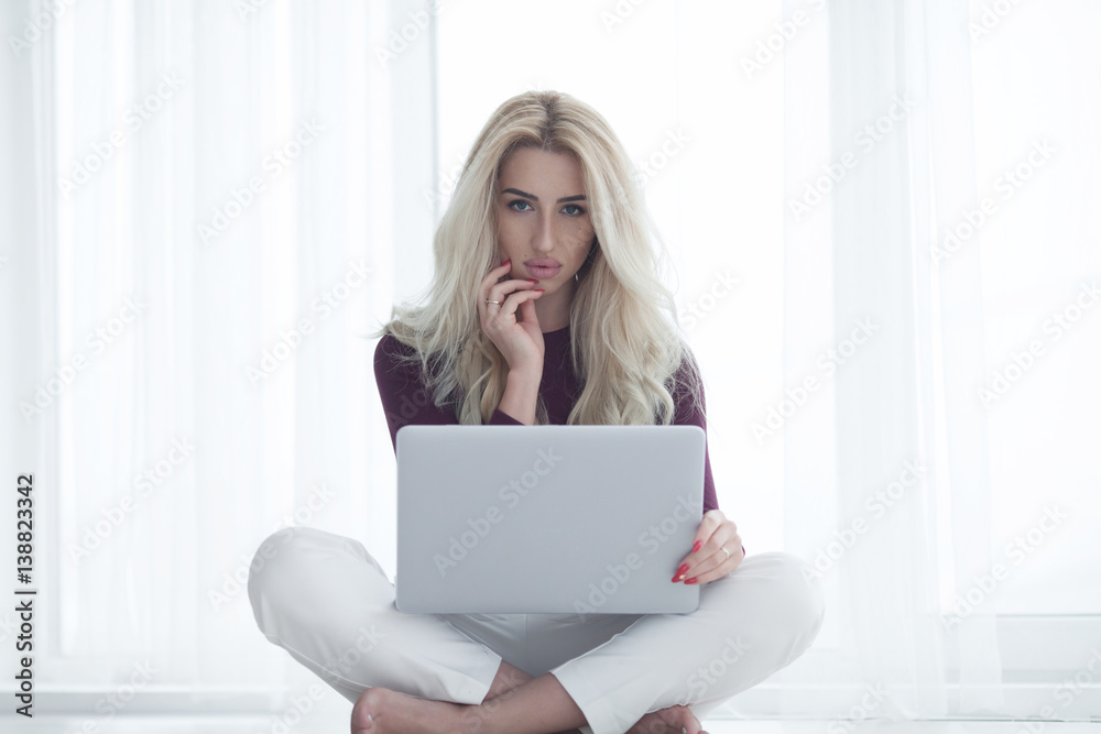 happy woman lying on a carpet with notebook smiling into camera in livingroom happy woman lying on a carpet with notebook smiling into camera in livingroom
