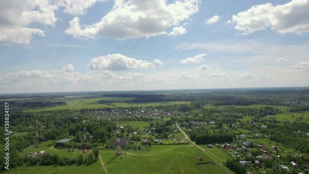Aerial panorama of vast green areas in Russia. Summer landscape with forests, fields, village and blue cloudy sky Aerial panorama of vast green areas in Russia. Summer landscape with forests, fields, village and blue cloudy sky
