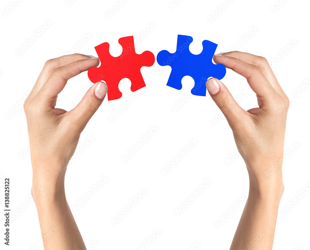 Red and blue puzzle in woman hands isolated on white background Red and blue puzzle in woman hands isolated on white background
