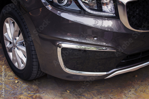 Front bumper dark grey color of luxury car in front-side view. © BLKstudio
