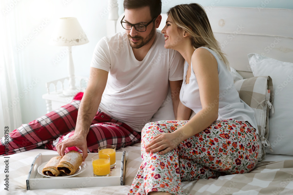 Couple eats breakfast in bed