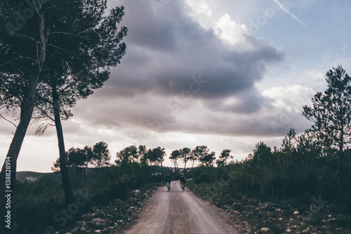 Obraz Dwóch rowerzystów jedzie na zachód słońca