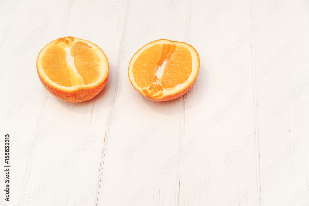 Two halves of an orange white wooden background Two halves of an orange white wooden background
