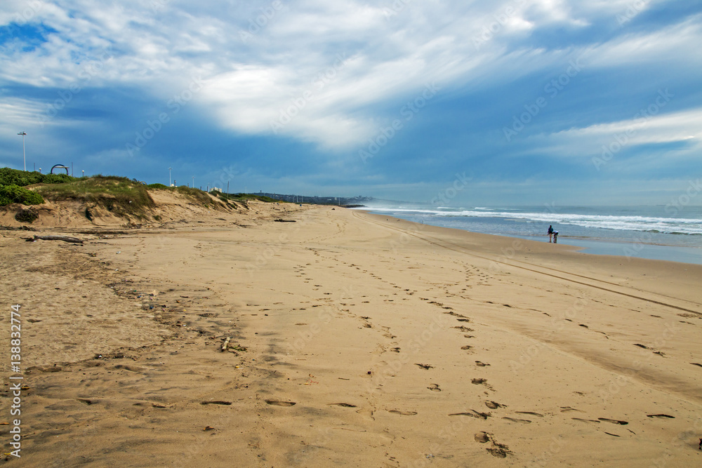 Sandy Beach Shoreline and Vegetated Dunes Against Blue Skyline