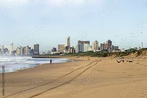 Sandy Beach Ocean and Waves Against City Skyline