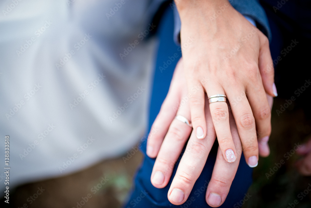 Hands of married couple with golden rings close up Hands of married couple with golden rings close up