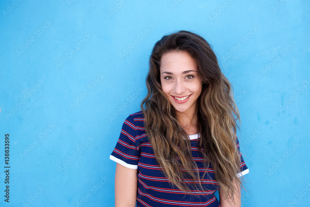 young smiling woman standing against blue background young smiling woman standing against blue background