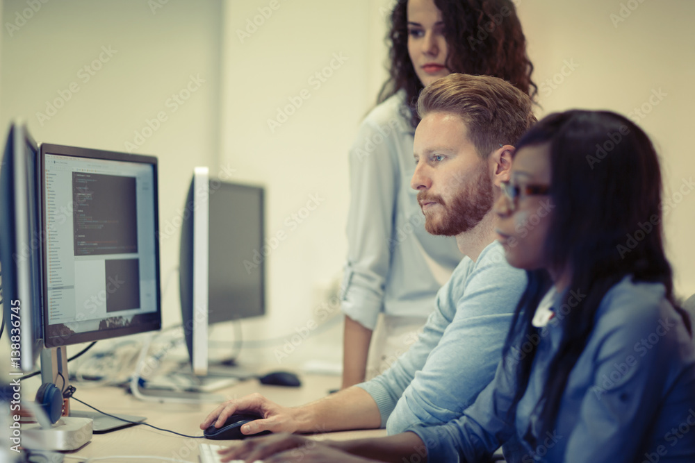 Programmers cooperating at information technology company Programmers cooperating at information technology company