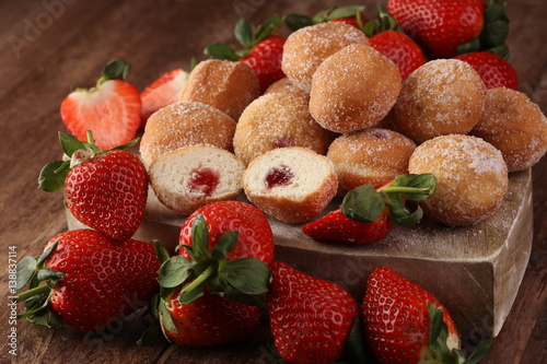 Bomboloni - traditional Italian doughnuts stuffed with strawberry jam photo