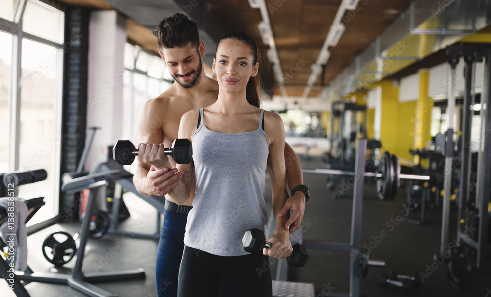 Personal trainer assisting woman lose weight Personal trainer assisting woman lose weight
