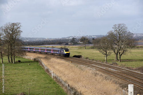 A First Great Western company passenger train passing through English countryside south of Exeter in Devon UK photo