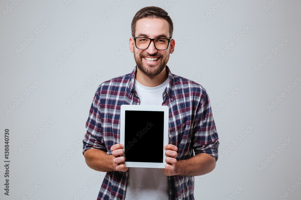 Bearded man in eyeglases showing blank tablet computer screen Bearded man in eyeglases showing blank tablet computer screen