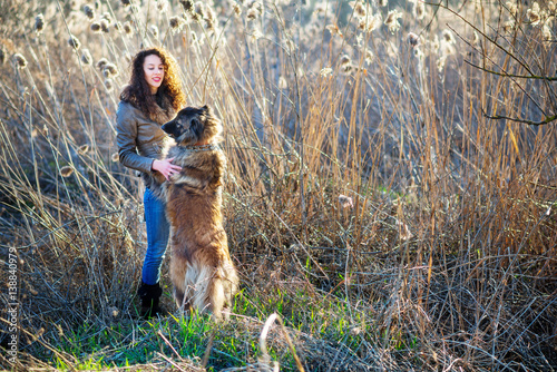 Girl playing with Caucasian shepherd dog, autumn photo