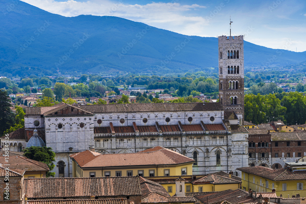Obraz premium Side ship and bell tower of the Duomo di San Martino in Lucca in the background the mountains_Lucca, Tuscany, Italy